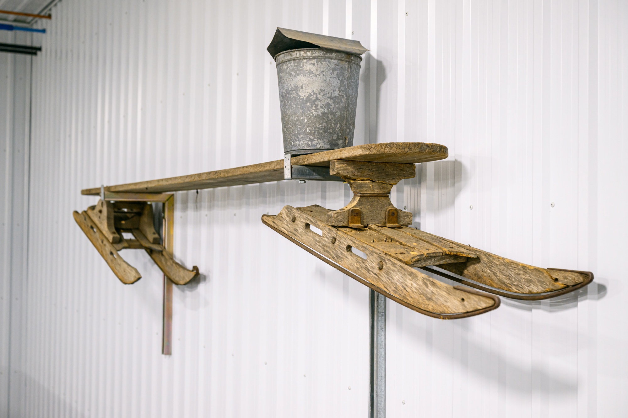 Antique sap bucket and wooden sled on display